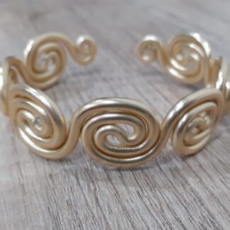Bracciale rigido dorato con spirali
