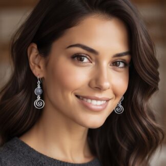 Close-up portrait of a smiling woman with long dark hair, wearing silver spiral earrings.